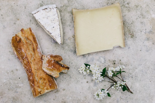 Flay lay of baguette, cheese, and edelweiss flowers