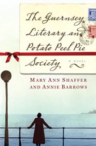 Book cover for The Guernsey Literary and Potato Peel Pie Society - woman standing on a quay looking out to sea