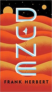 Dune book cover - orange and gold dessert planet with two planets or moons in the night sky
