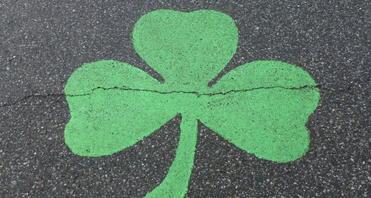 Green shamrock clover painted on a road
