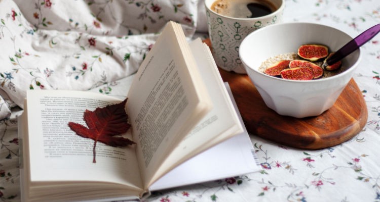 Open book with fall leaf, coffee mug, and bowl of figs
