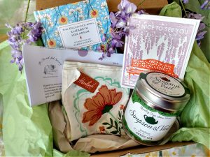 Book subscription box with The Enchanted April, floral scarf, tea tin, and notecard