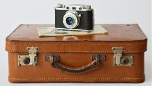 Old-fashioned camera on top of antique suitcase
