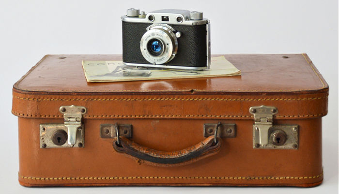 Old-fashioned camera on top of antique suitcase