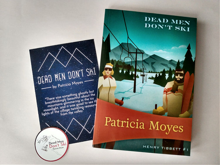 Mystery novel subscription club contents with Dead Men Don't Ski, sticker, and quote postcard