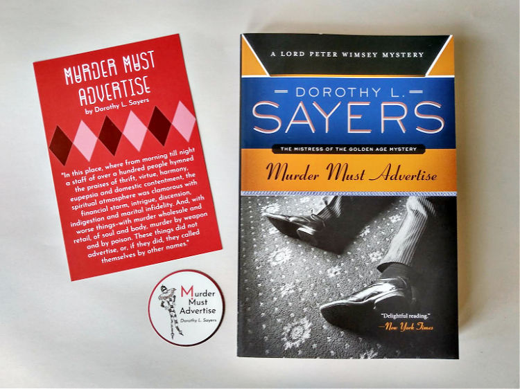Paperback copy of Murder Must Advertise with coordinating postcard and sticker