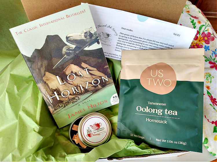 Book subscription box with Lost Horizon paperback, oolong tea pouch, and book darts
