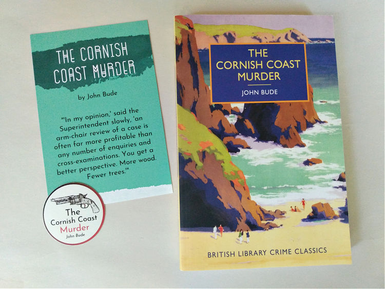 Paperback copy of The Cornish Coast Murder with coordinating postcard and sticker