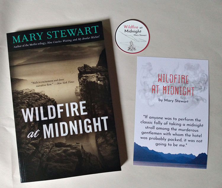 Paperback copy of Wildfire at Midnight by Mary Stewart, with accompanying postcard and sticker