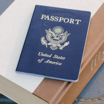 Passport on top of Jane Austen book, on top of suitcase