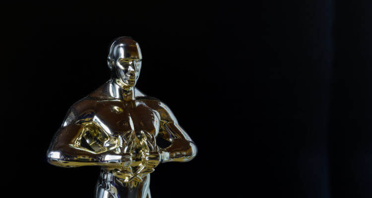 Gold Oscar-style statue trophy on a black background