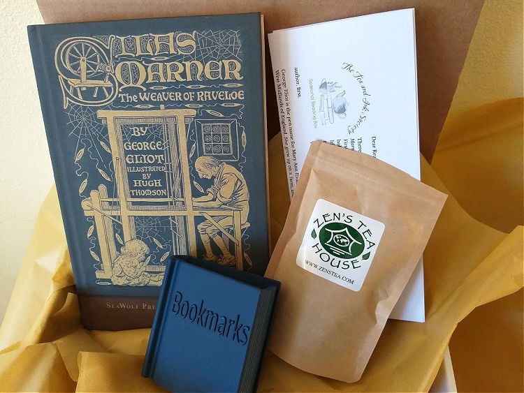 Book subscription box featuring hardback edition of Silas Marner, book-shaped bookmark holder, and paper packet of Lapsang Souchong tea.